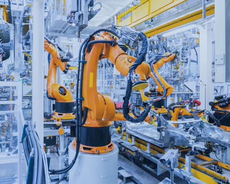 Automated robotic arms in a factory representing industrial automation
